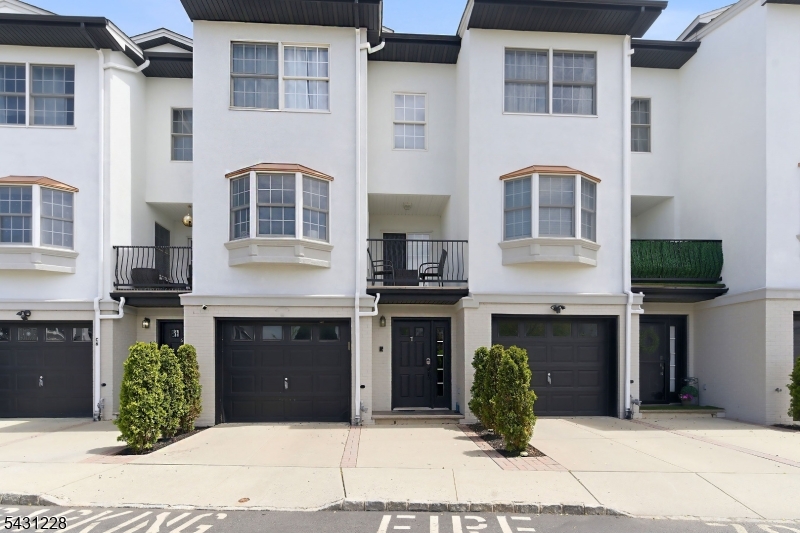 Thoughtfully updated, this spacious multi-level townhouse at Riverfront Residences offers comfortable living with modern touches throughout. The ground level welcomes you with a tiled foyer entry leading to a versatile family room with access to a private rear yard, as well as the garage, laundry room, a convenient powder room, and ample storage space. The main living level features hardwood flooring and an open, sun-filled layout ideal for everyday living and entertaining. The generous living and dining areas open to a private balcony, while the eat-in kitchen offers stainless steel appliances, granite countertops, a breakfast bar with seating, and a bright dining area with access to an additional balcony. A convenient powder room completes this level. Upstairs, the primary suite features vaulted ceilings, a private balcony with water views, and an en-suite bath with double vanity, whirlpool tub, and separate stall shower. A second spacious bedroom and full bath are also located on this floor. The top level offers a third bedroom and full bath, providing excellent flexibility for guests, work-from-home space, or extended living arrangements. Residents enjoy access to a private playground and a prime commuter location just minutes from the Elizabeth Train Station, NYC bus service, major highways, Newark Liberty International Airport, shopping, dining, and plenty of shopping.