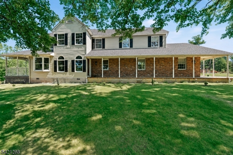 Cherished across three generations, this timeless custom Colonial is a rare offering that blends classic craftsmanship with thoughtful, flexible living. Gracefully maintained and set amid rolling farmland with sweeping country views, this inviting home exudes warmth, character, and enduring quality. A rocking-chair porch welcomes you into sun-filled interiors designed for both comfort and elegance. The main residence offers three expansive bedrooms, highlighted by a serene primary suite with walk-in closets, full bath, and private office retreat. 2 more generously sized bedrooms and another full bath complete the upper level. On the main floor, gracious living and dining spaces flow effortlessly into the kitchen, creating an ideal space for everyday living and entertaining. The beautifully designed guest suite provides exceptional privacy, offering its own bedroom, full bath, family room, and eat-in kitchen perfect for extended living arrangements or visiting guests. Throughout the home you'll find new flooring and carpet, and an impressive abundance of storage with closets at every turn. Step outside onto the deck to unwind and take in peaceful, pastoral views. A clean, unfinished basement provides ample storage or the opportunity for future expansion and walks out to the oversized two car garage. Sellers recently installed a brand new 4-bedroom septic system and a new roof. A truly special home offering space, versatility, and timeless appeal in a stunning country setting.