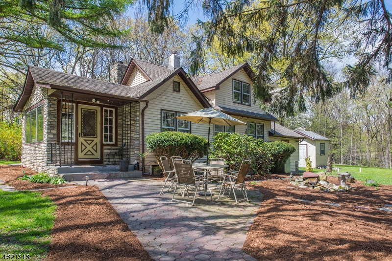 Cherished traditions and simple pleasures begin in this this enchanting cape-style home that sits back off the road on 2.57 tree-lined, level acres. Highlights include a light-filled knotty pine enclosed porch; wood floors; vaulted ceilings; stone fireplace with wood stove insert; functional kitchen; 18x9 sunroom; dining room; first floor office could be used as a bedroom; laundry room;  partial winder stairs lead to two second floor bedrooms; full bath features tub/shower.  Outdoor enjoyment is found sitting around the fire pit or al fresco dining on the paver patio adjacent to the charming water feature.   Two car detached garage is an added plus.  Laundry room can be converted to a Master Bath. Close to shopping, restaurants, parks and lakes.