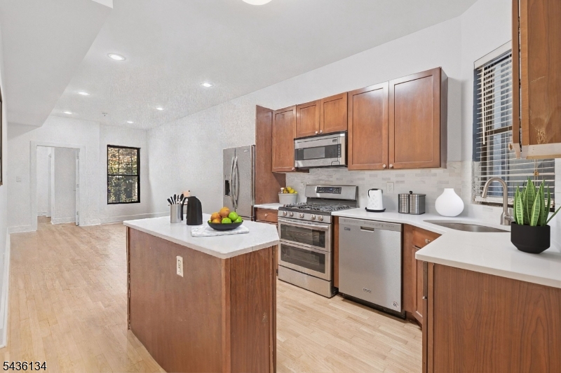 Unique, expansive and highly versatile 2-bedroom, 2-bath duplex offering 1,472 sqft of living space in the heart of Hamilton Park, featuring a full lower level that can function as a third bedroom, guest suite, home office, or additional living area. Rarely does a home offer this level of flexibility while maintaining a clean, functional layout. Flooded with natural light from multiple exposures, the main level features a bright and open living and dining area, complemented by high ceilings and hardwood floors throughout. The well-proportioned bedrooms offer generous closet space, and both bathrooms are well-appointed and thoughtfully designed. The kitchen has been recently updated with new countertops, along with a new water heater and newly refinished floors (2026). The lower-level shower was also renovated in 2022, creating a move-in-ready space.The expansive lower level nearly mirrors the footprint of the main floor and is complete with its own full bath, creating a true secondary living space ideal for a variety of uses. Additional highlights include central air and heat, in-unit laundry, and access to a well-maintained common outdoor space. This is the only unit in the building with direct internal access to both the common basement, shared patio. Perfectly positioned just moments from Hamilton Park, with easy access to dining, shopping, and transportation. Street parking is readily available, with discounted parking at Newport Mall and additional rental parking nearby