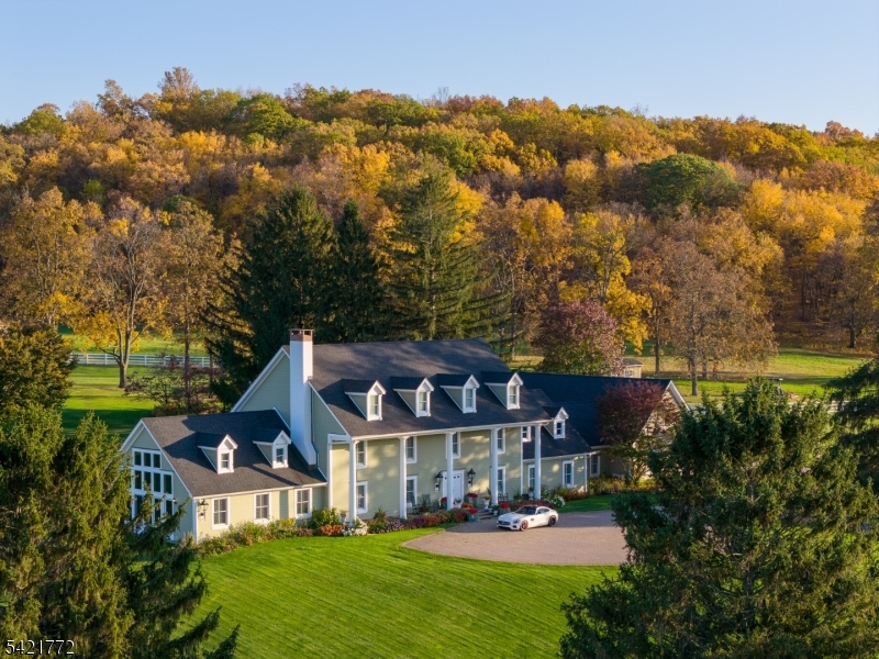 Hickory Hollow Farm presents a rare, once-in-a-generation opportunity to own and customize a private compound on 280 breathtaking acres. This extraordinary estate is anchored by a stately 5-bedroom, 4-bath colonial designed for flexible living. The main residence boasts graciously scaled rooms and timeless appeal, featuring a gourmet kitchen, private office, sunroom, a stunning family room with a double-sided fireplace, walls of windows overlooking the pond and rolling pastures, plus a cozy living room for intimate gatherings. Two bedrooms, including an en suite, are conveniently located on the main level. An oversized four-car garage with unfinished attic space above offers additional expansion potential. Upstairs, the primary suite is its own retreat with a spa-like bath and custom stonework, complemented by two additional bedrooms and a flexible living space ideal for a media room or playroom. Outdoor amenities include a tennis court, half basketball court, and a heated in-ground Gunite pool, all overlooking an impressive 11-acre spring-fed, fish-stocked pond with a fountain. Equestrian facilities include a main barn with 11 large stalls, wash area, feed room, hay room and loft, connected to a sand ring; a secondary barn with three oversized stalls; 17 grass paddocks with turnout sheds; 150? x 200? fenced-in FootingFirst riding arena; an equipment shed. A 2-bedroom, 2-bath guest house and 2-bedroom, 1-bath caretaker?s residence complete this exceptional offering.