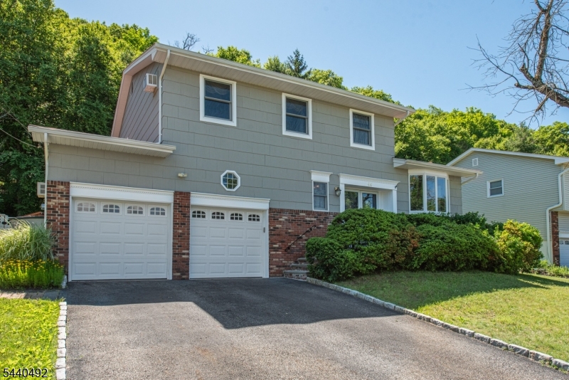 Welcome to 44 Molinari Drive, a beautifully maintained four bedroom, two and half bathroom, split-level Colonial offering comfort, style, and a functional floor plan in a sought-after Wanaque neighborhood with amazing mountain views. Warm hardwood floors flow throughout the home, creating an inviting atmosphere. The newly updated eat-in-kitchen features stainless steel appliances, ample dark wood cabinetry, and plenty of space for everyday living and entertaining. The spacious primary suite provides a private retreat, while the walkout lower level offers added flexibility for a family room, home office, recreation space, or guest accommodations. Step outside to a fenced backyard with a patio, perfect for outdoor dining, relaxing, and enjoying the changing seasons. Additional highlights include an attached 2-car garage, mature landscaping, newer windows, newer hot water heater and a convenient location close to schools, parks, and transportation. Move-in ready and meticulously cared for, this home combines timeless appeal with modern updates.