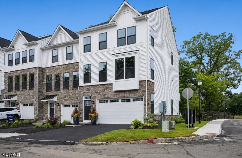 A wonderful opportunity to live in Montville's newest development, Doremustown Village, in one of the community's largest models! This premium end unit is situated on a premier lot and offers exceptional privacy. plenty of natural light, generous living space, and beautiful wooded views. Move right into this meticulously updated McPherson model, beautifully finished and ready for immediate occupancy. The ground level offers the potential for a finished fourth bedroom or home office, complete with a full bathroom and private walkout access to the wooded backyard. The main level showcases designer flooring throughout, an expansive open-concept great room and living area, a designer kitchen, a beautifully appointed powder room, and access to a private deck overlooking serene wooded grounds. Elegant fixtures and thoughtful finishes are featured throughout the home. The second floor features three generously sized bedrooms and two full bathrooms. The primary en suite boasts an ultra-custom bathroom and a custom-designed walk-in closet. Additional highlights include an oversized two-car garage with an automatic opener, a premium end-unit location on a premier lot, and the availability of a quick closing. There is no need to wait for new construction this exceptional home is brand-new, move-in ready, and waiting for you! Enjoy all that Montville has to offer including top-rated schools and proximity to the NYC train! Transferrable 10 Year Home Warranty is included.