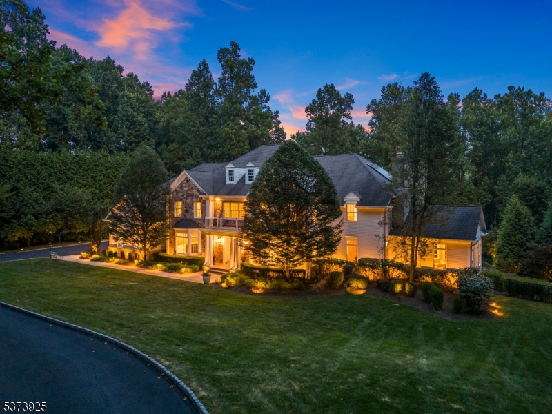 Perched atop the prestigious Bernardsville Mountain on a private cul-de-sac, this masterfully designed Colonial estate spans 7 acres of manicured grounds, offering an exceptional blend of timeless architecture, bespoke craftsmanship, & resort-style amenities. From the moment you enter the grand foyer, you're enveloped in elegance, soaring ceilings, intricate mill-work, & light-filled spaces flow throughout an open, yet refined, floor plan. The residence features 5 opulent bedroom suites, each w/ a private bath, & 6.2 bathrooms in total. The primary suite is a true private retreat, showcasing 2 expansive walk-in closets & a bonus room ideal for a nursery, office, or personal gym. The primary bathroom is palatial in scale & design, with spa-inspired finishes offering a sanctuary of luxury & calm. Host in style from the formal dining room w/ butler's pantry, cook & connect in the state-of-the-art eat-in kitchen, & work from home in the richly paneled study. Oversized windows & French doors invite natural light & frame stunning views of the grounds. The walkout lower level is a masterpiece in its own right, with 10-foot ceilings, fireplace, kitchenette, full bath, & direct access to 2 stone patios. Outdoor living reaches new heights w/ a resort-style pool & spa, expansive patios, & a detached multi-sports Pavillion, an athlete's dream come true, surrounded by vibrant gardens & mature landscaping. This estate offers an unmatched lifestyle of privacy, grandeur, & sophistication.