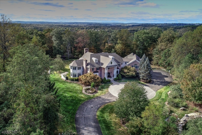 Custom built in 2001, this exceptional residence is situated on 10.14 acres in a neighborhood of luxury estates. An indoor pool and state-of-the-art media room make this home an entertainer's dream. The floor plan begins in a two-story foyer centered between the formal living room and dining rooms and leads to a two-story family/great room with views of the back lawn. A gallery hallway connects the sun room, library, and family room to a gourmet kitchen with breakfast area. Completing the first floor is an au pair suite, laundry room, indoor pool and access to a four-car garage. A sweeping staircase in the foyer leads up to a three-room suite that occupies one wing. Four additional bedrooms, the media room and a third powder room complete this level. Close proximity to Far Hills Country Day School.