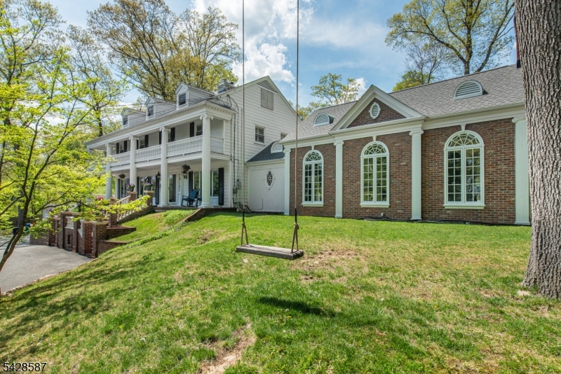 Rarely offered Southern Georgian Colonial in Morris Township's highly coveted Stardust Estates section, where you can enjoy the rare perk of low local taxes alongside almost an acre of private property. This massive 4-bedroom, 3.5-bath estate seamlessly blends classic vibes with luxury upgrades, making it the ultimate entertaining hub. The chef's kitchen features a La Cornue range and a built-in Miele coffee station, flowing perfectly into a custom cocktail bar. A jaw-dropping grand ballroom showcases cathedral ceilings and epic natural light, while the private primary suite offers a dreamy wraparound balcony. Wellness is built right into the home with a basement spa retreat and a fully fenced, expansive backyard oasis complete with a heated pool to enjoy all summer long against a backdrop of panoramic views. Completely move-in ready, this property gives you ultimate peace of mind with a brand-new roof, new HVAC, and whole-house water filtration. (Fireplaces/chimneys conveyed as-is; pool photos from previous season).