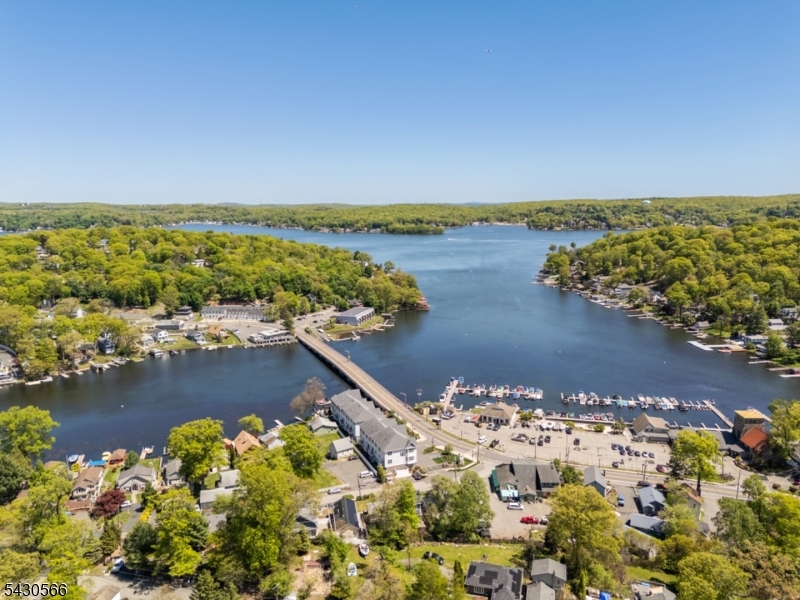 Set across 2 lots (8 Oneida Ave & 7 Riggs Ave + granted land) totaling over .50 acres, provides a rare opportunity to build your dream LAKEFRONT RETREAT in highly desirable No Wake Crescent Cove with stunning sunset views! Set on Lake Hopatcong, largest lake in NJ, this serene & secluded cove is an exceptional parcel offering the perfect canvas to bring your vision to life. The property captures breathtaking western exposure, delivering unforgettable sunsets & a tranquil waterfront setting ideal for both year-round living & luxurious weekend escapes. Enjoy swimming, kayaking, paddle boarding, & relaxing in calm waters of this protected no-wake cove without the disruption of heavy boat traffic. Opportunity to install a 4-bedroom septic system (approved by Sussex County Board of Health) allowing flexibility to design a custom home tailored to your lifestyle. With ample space & Hopatcong Land Use Board Approvals for a single-family home, 2-car detached garage, & boathouse (rare on the lake), you can create a seamless indoor-outdoor lake living experience. Imagine mornings on the water, afternoons boating & evenings unwinding as the sun sets over the horizon. Enjoy all that Lake Hopatcong has to offer, from vibrant waterfront dining & recreation to peace & quiet just a short distance from major highways, commuter routes & trains to NYC. Whether you envision a private getaway or a full-time residence, this is the time to secure prime lakefront land & build your dream. Survey, approvals & building plans are available upon request. THIS LOT IS SOLD WITH 7 RIGGS AVE MLS# 4028680. Last photo is a virtual rendering.