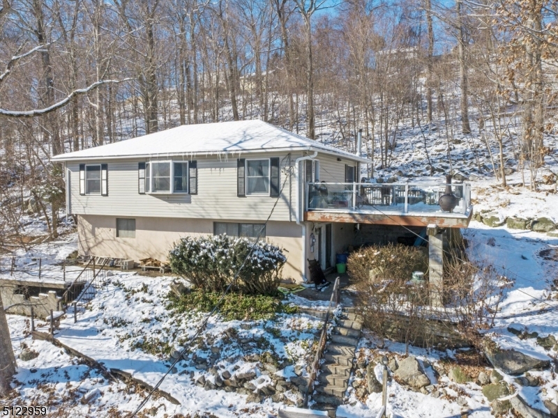 Privacy and Lake Views are yours to enjoy on this extra large lot, atop a hill over looking a beautiful cove of Lake Hopatcong. Lovingly cared for and updated, don't miss this 2 bed 1 bath home with many recent updates including redone hardwood floors for main living areas in 2017, new laminate flooring and ceiling fans for the bedrooms in 2014, brand new driveway in 2016, finished full walk-out basement in 2016, new hot water heater 2019, new dishwasher 2021 and new well pressure tank 2022. Additional great features include central vac, garbage disposal and built in Humidifier for forced air heating system. The family room has a wood burning stove. Move in and enjoy this special home with privacy and a larger lot which is hard to find in Hopatcong!
