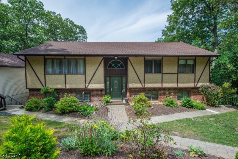 Immaculate, Custom Bi-Level located in Erskine Lake. Located on a large, private, wooded lot in Great Neighborhood. Lots of Generous Room Sizes to Spread Out & Make Your Own! Layout offers versatile options! GREAT house for entertaining or everyday living. Large living room & formal dining room with slider to back deck. Bright, eat-in kitchen- granite countertops & glass tile backsplash. Abundance of high hats & large windows -Lots of light! 3 large bdrms & 2 renovated full bath upstairs includes the primary suite w/bath (walker accessible stall shower). Oak hardwood flooring throughout. 3 additional office/den/flex rooms on lower level. Fully equipped w/the third full bath. Kitchenette area with separate entrance. Family room walks out to the lower deck. Convenient laundry/mudroom. Oversized detached garage. Over 2800 sqft of living. Seasonal Lake views. Tons of parking! 3 quarters of an acre. An ideal spot to relax on the deck & enjoy life amongst the tree line. Erksine Lake living! With membership, enjoy all the amenities- swimming, beaches, fishing, boating, sailing & more! Easy access to shopping, restaurants and Library on Skyline Drive or Wanaque. Top rated community with excellent schools! Natural gas and public water, tons of cosmetic upgrades already done!