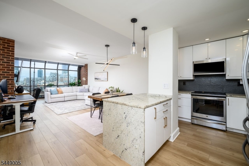 Penthouse-level residence at Clermont Cove offering 1,530 sq ft of refined living and a 132 sq ft southwest-facing private terrace with breathtaking, unobstructed Statue of Liberty and New York Harbor views. Filled with natural light, this exceptional home features exposed brick, luxury vinyl plank flooring, dramatic floor-to-ceiling curved walls of architectural glass, and terrace access from the living room and both bedrooms. The contemporary chef's kitchen boasts sleek white cabinetry, granite countertops, center island and stainless steel appliances. The spacious primary suite offers a custom walk-in closet and luxurious spa bath with Porcelanosa tile, dual vanity and oversized rain shower with body jets. A generous second bedroom, elegant hall bath with soaking tub, abundant closets, exceptional storage, in-unit LG washer/dryer and valet parking complete the home. Clermont Cove offers 24-hour concierge, pool, jacuzzi, fitness center, outdoor grilling area, bike storage, rentable storage units, and a resident lounge currently being renovated. HOA includes heat and water. Nestled along the coveted Paulus Hook waterfront, you're just steps from waterfront parks, acclaimed dining, cafés, boutique shopping, Whole Foods, highly rated PS16/Bradford School, Exchange Place and Grove Street PATH stations, and the NY Waterway Ferry for an effortless Manhattan commute.