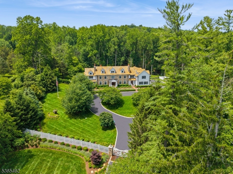 Nestled on 5.4 meticulously landscaped acres, this stunning renovated estate in Mendham is a true gem. Spanning over 9,000 sqft, the home features an impressive foyer with a soaring 25-foot ceiling, complemented by exquisite moldings, millwork, beams, paneling, and hardwood floors throughout. The chef's dream kitchen is equipped with high-end appliances, including a 6-burner Viking range, double ovens, Sub Zero refrigerator, and honed marble countertops.With 6 fireplaces, the home radiates warmth and natural light in every room. The luxurious primary suite offers a serene retreat with a sitting area, fieldstone fireplace, and dual baths with radiant heated floors. The estate includes 6 bedrooms and 7.2 baths, all with ensuite facilities for added convenience.The lower level is a walk-out oasis featuring a gym, study, office, wine cellar, and recreation rooms, perfect for entertaining. Outdoors, indulge in a resort-like experience with a pool, covered veranda, hot tub, fire pit, and a designer yurt overlooking a tranquil stream.Additional features include a whole-house generator and a 4-car garage with a lift for car enthusiasts. Conveniently located near shopping, dining, and transportation, this stately yet modernized estate is a unique opportunity not to be missed.