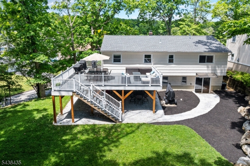 Welcome to 101 Pocono Trail! Located approximately one mile from Lake Hopatcong, New Jersey's largest freshwater lake, this beautifully updated home offers the perfect combination of modern upgrades and outdoor living. Extensively renovated in 2021, the home features updated electrical, plumbing, windows, kitchen, flooring, and more. A new roof was added in 2023, making this a truly move-in-ready opportunity. Step outside and enjoy a spacious second-level deck, perfect for relaxing or entertaining. Below, a covered stone patio creates an inviting outdoor living area complete with space for dining, gathering, and enjoying your favorite game or movie outdoors. The beautifully landscaped property features decorative boulders, natural stone accents, and impressive stone steps leading to the front entrance. Just minutes from boating, fishing, waterfront dining, and all that Lake Hopatcong has to offer, this home delivers the lake lifestyle without the waterfront taxes. Don't miss this exceptional opportunity!