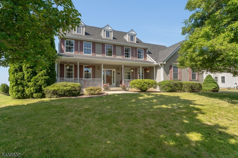 Beautiful Wyndham Farms Colonial on a Cul-de-Sac street! Meticulously maintained beautiful 4/5-bedroom, 2.5-bath Colonial home with a side-entry 2-car garage, set on one of Wyndham Farms' most desirable level and beautifully landscaped half-acre lots. A charming full front porch provides the perfect spot to enjoy your morning coffee or unwind at the end of the day. A dramatic two-story foyer welcomes you inside, where you'll find a flexible first-floor bedroom or office, spacious living and dining rooms, and an open floor plan designed for everyday living and entertaining. The bright eat-in kitchen features an island, abundant cabinetry, new lighting, microwave & dishwasher, and a sunny breakfast area with sliders to the backyard. The kitchen opens seamlessly to the vaulted family room with a fireplace, creating the perfect gathering space. Upstairs, the vaulted primary suite offers two walk-in closets and spacious bath with soaking tub, separate shower, and dual vanities. Three additional bedrooms and a full bath complete the second level. Recent improvements include a New Roof and a newly paved driveway with expanded parking. Outside, enjoy a lush, level backyard bordered by mature arborvitaes, creating a peaceful, park-like setting perfect for relaxing or entertaining. Huge basement with Bilco doors to yard; tons of great storage and room to finish in the future., updates, and convenience, this exceptional home is truly move-in ready.