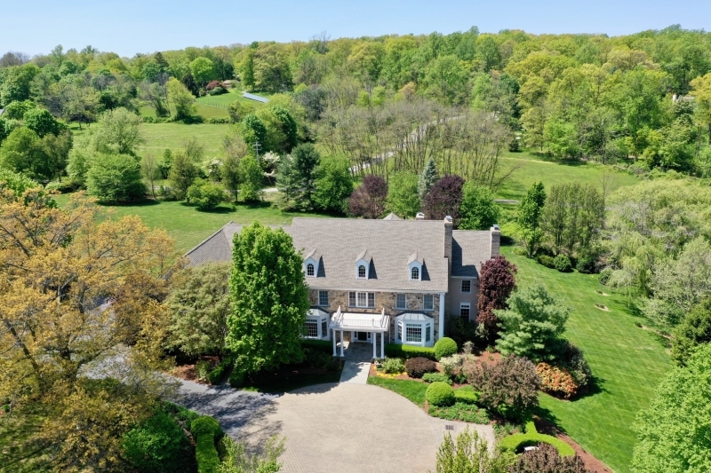 Nestled atop 5 lush acres on Bernardsville Mountain, "Ballantine Manor" seamlessly blends architectural style, comfort, and privacy just minutes from town. The antique gated entrance and tree-lined driveway lead to a stunning two-story foyer. High ceilings, wide hallways, and crown moldings create an inviting atmosphere, connecting living spaces. The great room, flooded with natural light, features a fireplace and a wall of windows framing picturesque views. The gourmet kitchen boasts top-of-the-line appliances as well as an inviting center island for casual dining and a breakfast area and octagonal gathering room with fireplace. The formal dining room and butler's pantry make entertaining a joy. The paneled library with fireplace is ideal for working from home. On the second floor, the primary suite is a tranquil oasis with a spa-like en-suite bath and a sitting room with a fireplace. Four additional generous bedrooms all with en-suite baths and a second floor laundry complete the second floor. The walkout lower level includes a recreation room, bar, home theater, study, and full bath. Outdoor spaces, including patios and a deck, provide a private retreat for relaxation and al fresco dining while the sprawling yard with specimen trees and plantings offers endless possibilities. Minutes from Bernardsville's town center, NYC trains, and excellent public and private schools, Ballantine Manor offers a lifestyle that has it all!