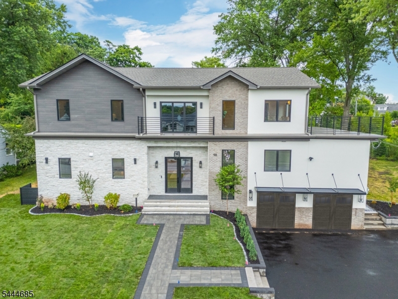 Mind blowing one-of-a-kind Montclair Heights luxury masterpiece breaking Clifton boundaries - apprx 4,750 sq home across multiple levels offers statement-making finishes & a meticulously planned jaw-dropping design. This 6BR 4.5BA home w/ 12 ft ceilings begins w/ a grand tiled foyer & entry bench plus storage that leads to an open-concept layout featuring a LR anchored by a stunning gas fireplace under arched built-ins, an open dining area, a chef's kitchen, qrtz counters, premium appliances, & an oversized island. Rear rec room has 23-ft cathedral ceilings, multiple skylights w/ shades, & a party-ready bar & island offering an ice maker, undercounter refrigeration & a wine cooler. The rec room has its own private BR & full BA. The rec room & LR have multi-panel sliders & 8 ft windows for tons of natural light & easy access to the yard. Out back, in your sun-filled level backyard, chillax on your patio or under your oscillating-roof pergola. A few steps from the main level brings you to the 1st primary suite with 2 massive WICs. Upstairs features 2 BRs with expansive WICs, a private office/6th BR, a laundry w/ abundant storage, & a luxurious 2nd primary suite w/ vapor fireplace. Both the hallway & the upstairs suite offer direct access to a huge outdoor deck w/ spectacular seasonal NYC skyline views. Finished bsmt includes a 2nd laundry hookup & rec space. 4-car garage w/ EV charger, driveway parking for 6 cars. Generator. Close to parks, restaurants, shopping, & NYC transp.