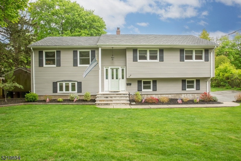 Expect to be impressed!!! The care and Maintenance is incredible! Great curb appeal with a flat expansive yard for outdoor entertaining! Plenty of driveway parking. Walk into this home that has hardwood floors, tile that emulates hardwood., large living room, dining room and a kitchen that has been remodeled with granite counters , back splash, and sliding glass doors to large deck with motorized awning. Primary bedroom with full bath, plus 2 other bedrooms. Pull down attic stairs. Wood hand rail going to lower level. Extra large family room instead of the fourth bedroom, surround sound audio system, recessed lighting. Cornice and base molding. This home will truly not disappoint!!