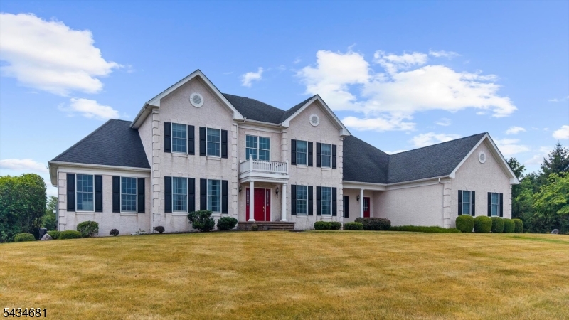 Perched on one of the most generous parcels within prestigious Hunterdon Hills Estates, this expanded Toll Brothers Coventry unfolds across more than 7,000 square feet of meticulously crafted living space. Light floods through oversized windows, illuminating rich finishes and an unbroken layout that carries you from the formal living and dining rooms. The kitchen anchors the home with a commanding 10-foot center island, six-burner Viking range, a butler's pantry, and a sun-drenched adjoining conservatory framing views of the backyard. A first-floor bedroom or private study with an adjoining full bath brings welcome versatility to the layout. Upstairs, four generous bedrooms each claim a private ensuite, crowned by a primary retreat with dual walk-in closets and a serene bath featuring a deep soaking tub and an oversized glass shower. The walkout lower level was built for gathering, boasting a custom live-edge bar, wine cellar, home theater, private gym, multiple beverage fridges, and an indulgent steam shower. Beyond the walls, a multi-tiered paver terrace cascades toward the sprawling backyard, forming an idyllic backdrop for entertaining under open sky. Rounding things out: a whole-house generator, a GarageTek-outfitted garage, and impeccable craftsmanship at every turn make this one of Raritan Township's finest luxury residences, a genuinely rare find.