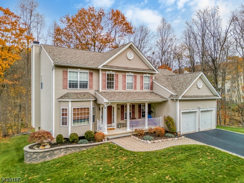 Quietly set on a premium lot with woods creating privacy on three sides, this turn-key colonial offers a setting that feels calm, comfortable, and intentionally private. Designed for everyday living, the home spans over three levels and includes five bedrooms, two full and two half baths, all wrapped in a designer inspired color palette that enhances the home's classic style. The interior unfolds with a two story foyer, bamboo hardwood floors, abundant natural light, and a floor plan that balances openness with well defined living spaces. The kitchen anchors the home, featuring a spacious dining area with direct access to the rear deck, a granite peninsula ideal for casual meals, and seamless connection to the family room. Formal living and dining rooms provide flexibility for gatherings, while a first floor bedroom, laundry room, and powder room add everyday convenience. The second level offers four additional bedrooms and two full baths, including a generously sized primary suite with a walk-in closet and ensuite bath with dual vanities, a soaking tub, shower, and a water closet. The finished walk-out lower level expands the living space with approximately 1,000 square feet of versatile space suited for recreation, work, or hobbies. All this and a new roof and hvac! With its flexible design and private setting, this home offers refined living in one of Lake Hopatcong's most sought after neighborhoods.