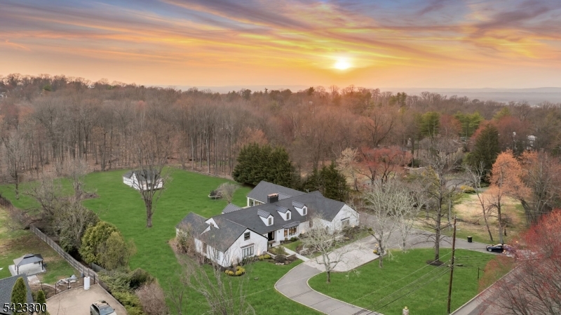 Welcome to 16 E Greenbrook Road situated on a pristine 2.44-acre parcel in the sought-after enclave of North Caldwell, This home presents a rare opportunity to own a fully renovated estate offering modern luxury. Set on an impressive 255 x 470 lot that backs to preserved woodlands, this residence delivers a tranquil, park-like setting while remaining just 19 miles from New York City. This unique modern ranch is over 5000 sq ft.  Fully renovated in 2021 offering an ideal layout for everyday living and entertaining with 5 bedrooms and 5.5 bathrooms in the main house. This property has distinctive features such as an indoor pool  . Enclosed within a dramatic space of sliding glass doors and 20+ foot vaulted ceilings. This area offers remarkable versatility and can be reimagined as a private indoor sports court, or bespoke venue tailored to your vision. Beyond the main residence, a fully renovated barn enhances the homes functionality. Thoughtfully updated, this space includes a full bathroom, garage door to open up the space and lofted bedroom.  The barn offers endless possibilities to suit a modern lifestyle. The expansive grounds further distinguish this property, providing both usable open space andthe natural beauty of wooded surroundings. The depth and privacy of the lot create an exceptional outdoor environment with ample room for recreation, entertaining, future enhancements, or simply enjoying the peaceful setting Welcome Home!