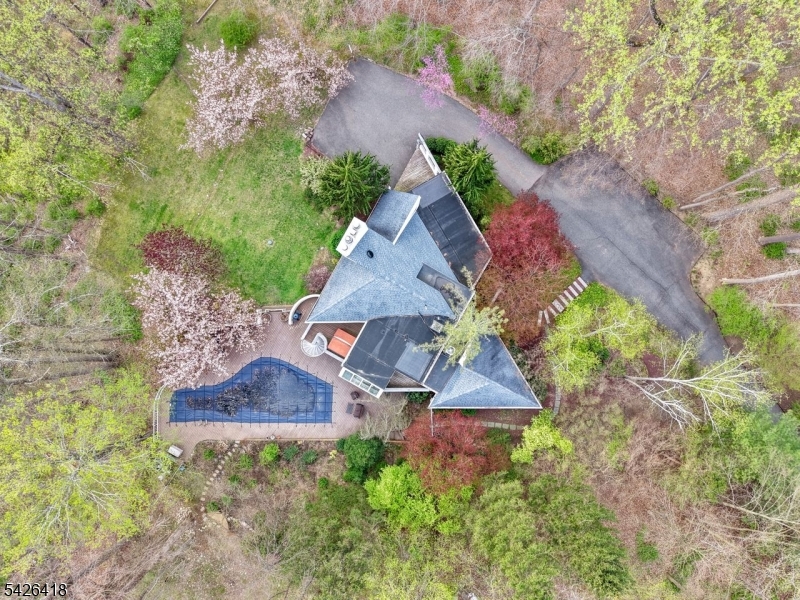 Tucked away on over 3 private, wooded acres just minutes from the vibrant heart of Morristown, this one of a kind custom home offers the perfect blend of luxury, character, and convenience. A rare opportunity to enjoy total seclusion without sacrificing access to one of New Jersey's most sough after downtowns, known for its lively dining scene, boutique shopping, and direct train service to NYC.Inside, the home showcases distinctive architectural design with soaring ceilings, rich Brazilian hardwood flooring, a gourmet chef's kitchen with SubZero, Jennair appliances, a super generously spa like sized Master Bath and thoughtfully crafted spaces that sets it apart from anything else on the market. Each room feels intentional, warm, and full of personality, ideal for both everyday living and entertaining.The fully finished lower level features a cold room, perfect for use as a wine cellar, guests room, storage, or specialty space tailored to your lifestyle. Step outside to your own private retreat: a heated in-ground pool surrounded by nature, offering a resort-like setting right in your backyard. Whether hosting summer gatherings or enjoying quiet mornings, the expansive property delivers unmatched tranquility and space.A true hidden gem, offering the best of both worlds: minutes to downtown Morristown, yet worlds away in privacy, serenity, and style. Call me for your private tour today