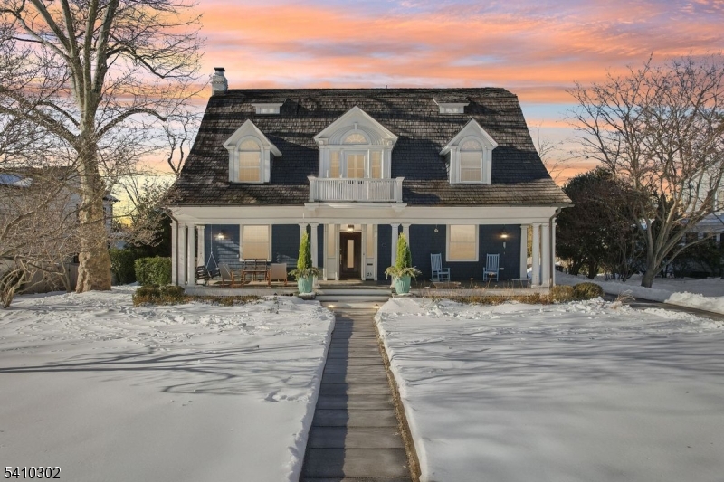 This beautifully renovated early twentieth century Dutch Colonial Revival home blends historic charm with modern living in sought after Stoneleigh Park, just moments from downtown Westfield, top rated schools, and the NYC train. Thoughtfully redesigned by the award winning team at AHD & Co., the residence balances architectural integrity with contemporary comfort. The project received the AIA Bronze Award in Historic Preservation.The light filled kitchen and dining area create an open, inviting hub for everyday living and entertaining, enhanced by a new scullery for added storage and function. Warm white cabinetry, classic subway tile, and a marble topped island anchor the space. The living and family rooms offer refined yet comfortable gathering areas with abundant natural light and strong indoor outdoor connection. A wood burning fireplace warms the living room, while a cast stone gas fireplace highlights the family room.The home offers five bedrooms, four full baths, and one half bath, including a private primary suite with radiant heated marble floors, walnut cabinetry, and a soaking tub. Updated hall baths serve the upper levels.Outdoor spaces feel like a private resort with a saltwater pool, cabana, mature landscaping, and blooming hydrangeas. Stoneleigh Park is prized for its winding streets, park like setting, and architectural heritage, making this a rare and special offering.