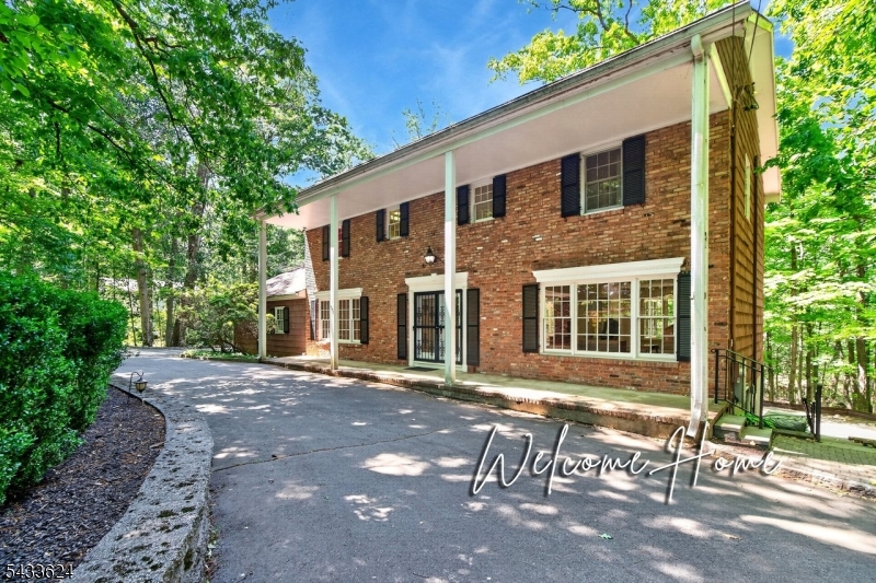 Offered for the first time by the original owner, this classic center-hall Colonial sits on 2.28 acres with a circular driveway in a highly desirable setting. The home invites updating and offers a rare opportunity to renovate and customize. The traditional layout features spacious living and dining rooms and a family room with a brick fireplace that is open to the large center-island kitchen. The kitchen includes a Sub-Zero refrigerator, granite countertops, dual sinks, stovetop, wall oven and a sun-filled vaulted breakfast room with skylights. A paver patio is accessed directly from the kitchen level. Upstairs are four bedrooms with hardwood floors, including a primary suite with private bath and ample closets. The walk-out basement provides excellent storage, future finishing potential and opens to a second expansive paver patio and private backyard ideal for recreation and entertaining. Convenient to top-rated schools, parks, shopping, dining, major highways and NJ Transit. Updates include boiler and hot water heater (2017), 20 kW generator (2013), chimney liner (2012), and AC (2007).