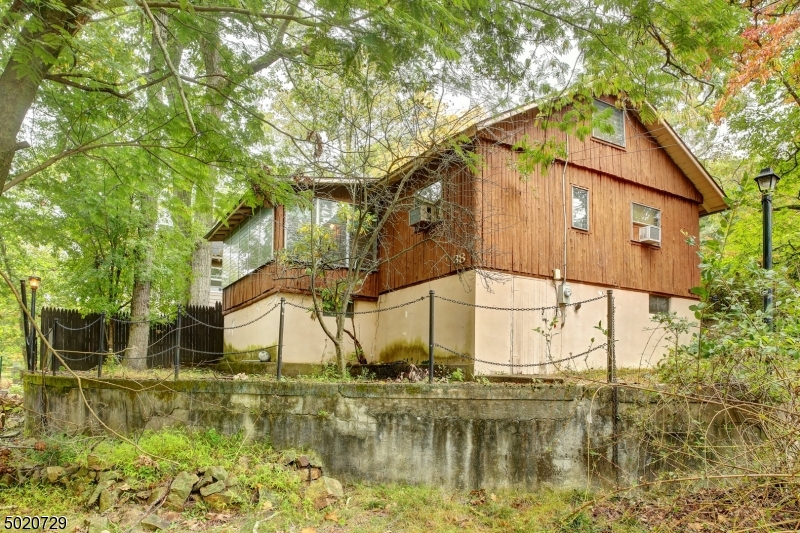 WELCOME HOME TO THIS 2 BEDROOM, 1 BATH CAPECOD NESTLED IN THE LAKE COMMUNITY OF WILDWOOD SHORES! Nostalgia and character make this home irresistible! A private lot w/a concrete patio greet you as you walk into the kitchen and breakfast dining area.  A wood burning fire place w/wood mantel and wall to wall carpeting make this spacious family room nothing short of perfection.  An enclosed porch sits off the family room giving you the real feeling of lake life.  Two full size bedrooms and a full bath complete the first floor.  Stairs lead up to two rooms which can be used as an office, spare bedroom or even a playroom! Do not miss your chance at a lake community! Present ALL Reasonable offers!, AS IS