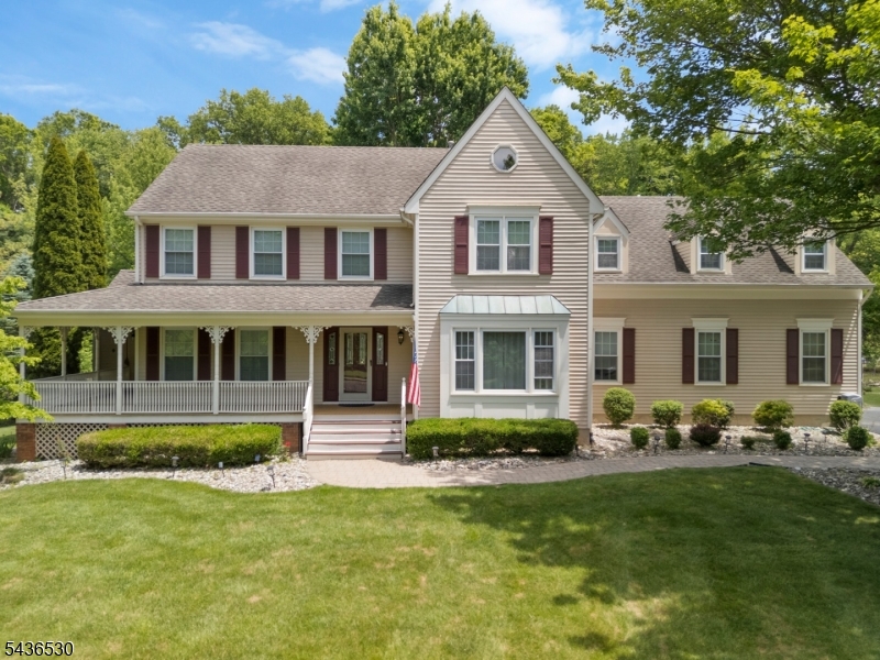Situated on a beautifully landscaped lot, this sun-filled 5-bedroom, 3.5-bath Colonial combines timeless elegance with modern comfort. Featuring exceptional curb appeal, a classic wraparound front porch, and thoughtfully updated interiors, this meticulously maintained home offers both sophisticated living and everyday functionality. A welcoming foyer opens to the formal LR and DR, highlighted by neutral d cor and abundant natural light. The eat-in kitchen features granite countertops, a center island w seating, ample cabinetry, and generous workspace. The kitchen opens to an expansive Brazilian IPE deck and charming gazebo overlooking the beautifully maintained backyard. The FR serves as the heart of the home, boasting soaring ceilings, a w/b fireplace, and windows with picturesque property views. Direct deck access creates seamless indoor-outdoor living. The first floor also includes a private home office, laundry room, updated powder room, and direct access to the attached two-car garage. Upstairs, the spacious primary suite offers a walk-in closet and a renovated spa-like bath. Four add'l bedrooms and two updated full baths with double vanities provide comfortable accommodations for guests. A versatile bonus room adds flexible space for work, study, or recreation. Conveniently located near top-rated Bernards Twp schools, parks, downtown amenities, and NYC train and bus service, this exceptional home offers the perfect blend of space, comfort, and classic suburban living.