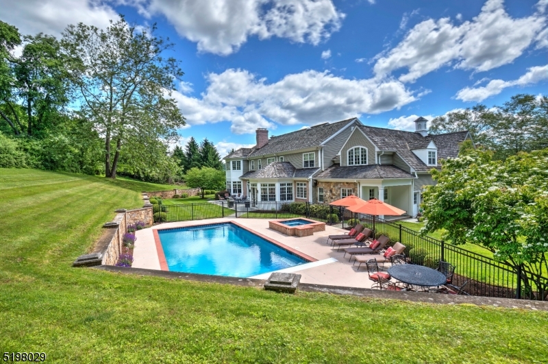 This stunning custom center-hall colonial is situated on 7.3 breathtaking acres with views over Pleasant Valley. The residence offers sophistication and style at every turn. Exceptional architectural details are evident including fine millwork, a boxed-beam ceiling, archways, deep crown moldings and mahogany doors. The grand entry foyer offers two guest closets, a herringbone pattern oak floor and custom chandelier. The designer kitchen offers a center island with breakfast bar, breakfast room, walk-in pantry, two dishwashers and handsome cabinetry. A raised-hearth stone fireplace anchors the family room and two sets of French doors open to the terrace. The library provides a wonderful home office.  The solarium is currently used as a Billards room. A door from this room opens to one of two open porches. The living and dining rooms have inlaid wood floors. There are a full bath and powder room on the first floor. The primary suite offers the bedroom with fireplace, two custom dressing rooms, sitting room, private porch and luxurious bathroom with two showers and two water closets. Four additional bedroom ( one with a sitting room), three bathrooms, laundry room and a marvelous leisure room complete this level. There is a walk-up attic. A glorious pool and spa, stone walls and beautiful landscaping highlight the rear yard. Fine dining, shopping, golf courses and equestrian facilities abound.  Convenient to public and private schools and Newark Liberty International Airport.