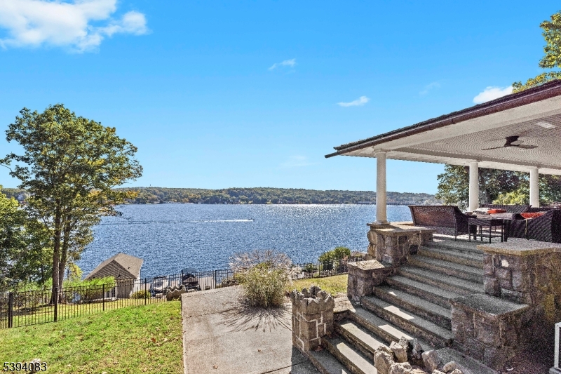 The Jewel of The Lake - - this grand Victorian estate boasts over 1.4 acres of pristine lakefront living with 115 feet of shoreline and unmatched panoramic lake views. Enter past a Vintage 1890's Carriage house to the main home, which features a sprawling covered porch, rounded turret & natural stone foundation. This spacious estate has been renovated to maintain and highlight its architectural glory with updated modern luxury amenities. The home features an open concept main living floor with refinished hardwood flooring throughout, and a stunning stone fireplace. The main living floor opens to a dining room perfect for entertaining. The tastefully renovated kitchen is fit for a chef and opens to a huge side patio with unparalleled views of the lake making it ideal for indoor/outdoor entertaining. The second and third floors of the Victorian home host 5 bedrooms,including a primary suite and 3 renovated bathrooms. You will find a vast dock just a short trip down to the lake with a stunning two story renovated boat house with beautiful living quarters on the second floor. Here you can also enjoy your large lakeside patio with deep water and space for multiple boats and water toys.