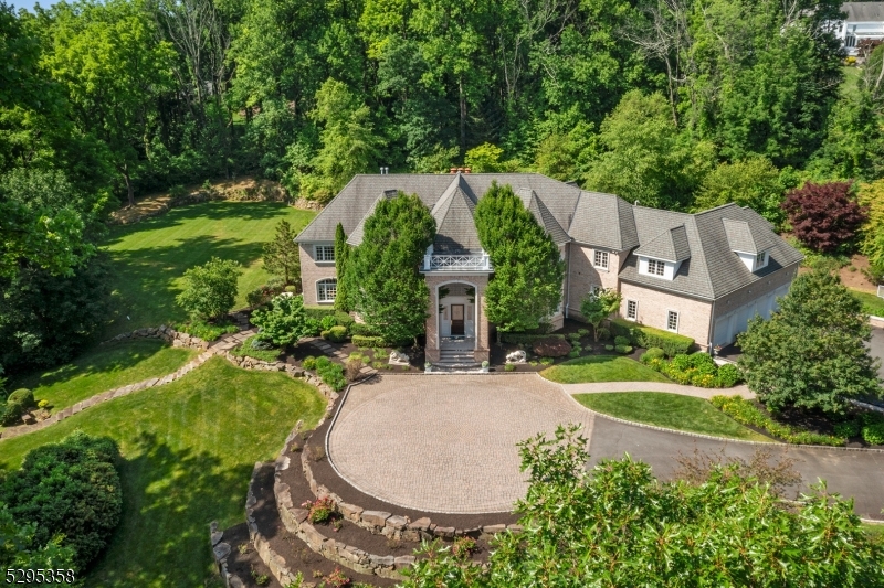 Step into this majestic, French Normandy Chateau, & be transcended to the European countryside. Regally nestled on a breathtaking 5-acre, gated property w/ panoramic views, this magnificent 8,000 sq/ft estate, features 5 BR, 6.1 baths & 4 garages. Exquisite European detailing is reflected throughout, incl the dramatic entry foyer's circular staircase w/ its oak railing & forged metal balusters curving gracefully to the 2nd floor. Pre-cast limestone abounds in the magnificent, 2-story great room FP, & on walls, pilasters, & moldings of the old-world formal dining room. The custom library is adorned w/ mahogany & cherry wood finishes, while limestone flooring graces the foyer, dining room, kitchen & more. Gorgeous molding/detailing & beautiful windows fill the 1st floor w/ an abundance of natural light. On the 2nd level, the primary suite boasts a spacious BR w/ marble, 2-sided FP & inviting sitting rm. The lovely primary bath is appointed w/ limestone flooring, marble-tiled shower, jetted-tub, private commode, & a huge WIC. Two generously sized BR en suites & J&J BR complete the 2nd floor. The 3,000sq/ft fin LL creates more exceptional space w/ media room w/ FP, expansive rec room, kitchenette, exercise room, wine cellar, full bath & storage/utility closets. An exquisite exterior consisting of a gorgeous paver patio, heated, gunite pool w/ waterfall, 3-golf chipping stations, firepit, prof landscaping, lantern lighting & more, this home is the definition of elegant living.