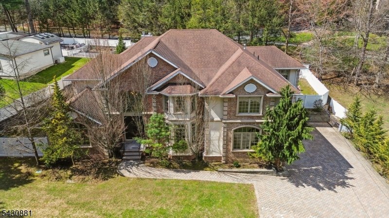 Elegant Center Hall Colonial on Closter?s coveted East Hill, built in 2008 & offering approximately 5,300 sq ft of thoughtfully designed living space. This impressive residence features 7 bedrooms,5 full bath & 1 powder room, blending comfort & refined style throughout. A grand two-story foyer with a coffered ceiling sets the tone & opens to a formal dining room with glass pocket doors & a sophisticated living room with a cathedral coffered ceiling. A sweeping staircase adds architectural elegance. The main level includes a first floor bedroom suite with a full bath, chef?s kitchen that flows seamlessly into the inviting family room with a fireplace and a private office with custom cabinetry. Upstairs accessible by two staircases, the luxurious primary suite offers a gas fireplace, spa-like bath & walk-in closet. Four additional spacious bedrooms are complemented by two Jack-and-Jill baths, along with an additional office, laundry room & a comfortable sitting area. The fully finished basement enhances the home with a bedroom, full bath, home theater, expansive recreation space, wine cellar, versatile bonus room ideal for a gym or office & abundant storage. Outside, a private fenced backyard provides the perfect setting for entertaining or relaxing. Additional highlights include a two-car garage, multi-zone heating & cooling, and a full-home natural gas backup generator. Ideally located near Manhattan, shopping, dining, and top-rated schools.