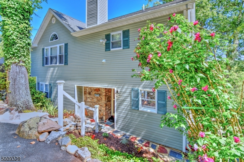 LAKEFRONT LIVING! Escape to Lake Tamarack for peace & privacy in this perfectly proportioned 3 bed, 2 full bath light-filled home. Updated kitchen w/ granite countertops & eat-in area, inviting living room w/ wood burning FP & dining area. Each room embraces beautiful lake views thru walls of windows. Wake up each morning in the large master bedroom w/ cathedral ceilings & a picture-perfect lake view. Freshly painted, updated main floor full bath with guest room or work-from-home office. Lovingly cared for home truly move-in ready!  Maintenance-free deck overlooking the lake & private boat dock. Enjoy all year recreational activities, near Mountain Creek ski area and Crystal Springs Golf. Convenient to the Express Park & Ride to NYC. Less than 1 hr drive to NYC
