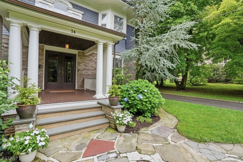 Step into a home where history meets luxury, and prepare to fall in love. This stately four level residence in Montclair's coveted Estate Section blends timeless architectural elegance with the latest amenities, hardwood floors, custom millwork, built-ins, pocket doors, cove ceilings, four fireplaces, and hidden powder room, all thoughtfully preserved. A grand foyer, anchored by a striking fireplace and dramatic staircase, sets the tone from the moment you enter. The main level offers a library, a formal dining room with fireplace, a distinctive living room with fireplace, a sun-filled den, and an enclosed three season porch. The gourmet kitchen is the true heart of the home Sub-Zero refrigeration, custom cabinetry, quartzite counters, and seamless access to a beautiful mudroom. Upstairs, the primary suite offers a private retreat w/ an exposed brick fireplace, a charming bay window seat, and a classic bath. Three additional light-filled bedrooms and a newly renovated full bath complete the second floor, while the 3rd floor adds two more bedrooms plus an updated bath. The partially finished basement includes a rec room, laundry room, and additional storage. Outside, impressively landscaped grounds and a rare 3 car garage complete the picture. The fenced yard is your own private oasis, a bluestone patio, mature shade trees, and flowering gardens. All just moments from NYC transportation and Montclair's vibrant downtown, with acclaimed restaurants, boutiques, and theaters.