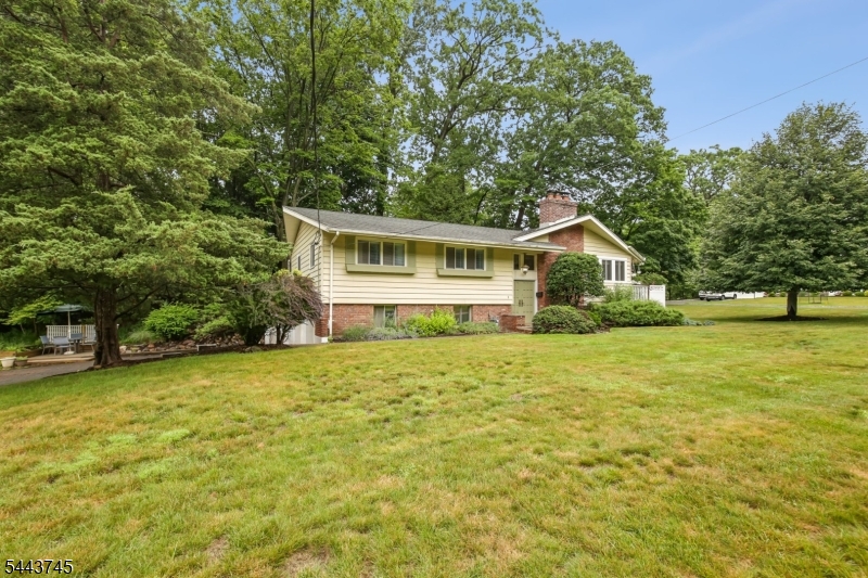 Perfectly situated on one of Ridgewood Acres' most desirable and rarely available cul-de-sacs. This oversized sun drenched corner lot is conveniently located within a short distance to the express Port Authority bus stop for an EASY COMMUTE to NYC, access the peaceful West Essex Hiking Trail within the street's bordering woods, and utilize one of the only elementary school bus stops in town.Inside, thoughtful updates and amenities include central air, two fireplaces, a heated oversized two-car garage, a Tesla charging connector, and a transfer switch for the included dual fuel generator. The main level offers three bedrooms, including a primary suite with its own private bath, plus an additional full hall bath. The finished lower level features a theater-ready space with projection screen included, a versatile bonus room, laundry, and a half bath. Within one of Cedar Grove's most sought-after neighborhoods, 5 The Glen offers the perfect combination of a friendly community, convenient commuter access and the tranquility of living within a woodland bordered cul-de-sac.
