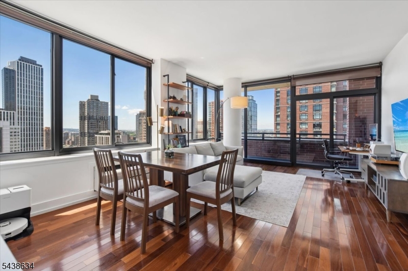 Beautiful 23rd-floor corner residence in one of Downtown Jersey City's premier full-service condominium buildings. This spacious 2-bedroom, 2-bath home offers sweeping city and water views, a private balcony, abundant natural light, and exceptional location just across Hudson River from Manhattan. Open-concept living and dining area has floor-to-ceiling windows and hardwood flooring, creating a bright and inviting atmosphere. Private balcony extends living space outdoors and provides the perfect setting to enjoy the surrounding skyline views. Chef-inspired kitchen features granite countertops, stainless steel appliances, abundant cabinetry, large center island, and oversized windows. Both bathrooms tastefully finished with modern vanities, illuminated mirrors, and spa-like fixtures. Generously sized bedrooms offer hardwood flooring, large windows, and excellent closet space, creating comfortable private retreats. Enjoy the convenience of a full-service lifestyle with doorman service, on-site parking garage, contemporary lobby, fitness center, resident lounge, playroom, landscaped outdoor terrace, and grilling area. Ideally situated in one of Jersey City's most desirable waterfront neighborhoods, this home boasts a Walk Score of 96 and offers easy access to PATH trains, Light Rail, ferry service, waterfront parks, acclaimed restaurants, shopping, and the vibrant energy of Downtown Jersey City.