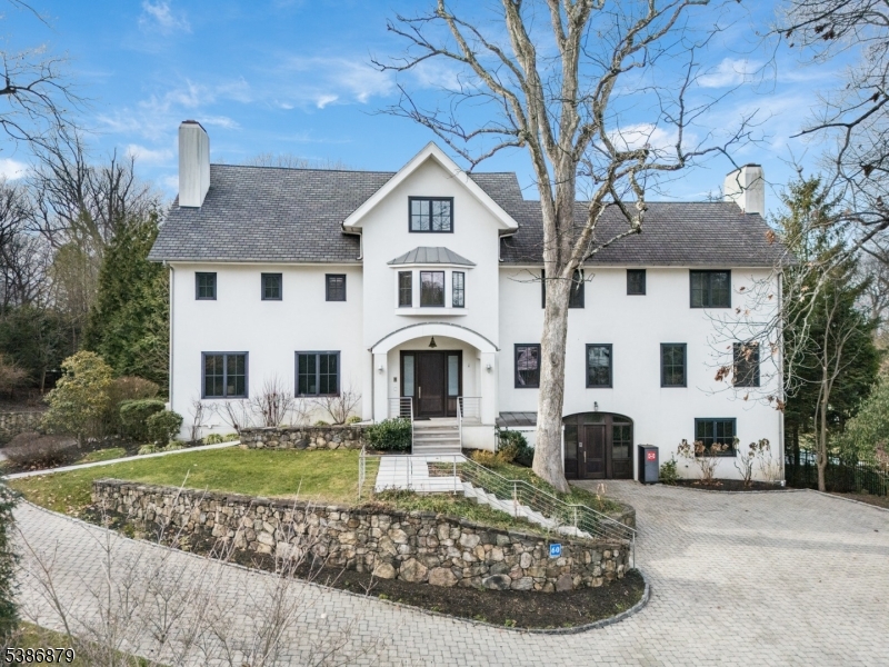 BOLD MODERN LUXURY ON SUMMIT'S COVETED NORTHSIDE ? 1.8 Private Acres. Early 20th-c. home completely reimagined in 2011 into 9 Bed/7.2 Bath showpiece sure to impress all who cross her threshold. Grand circular driveway leads to home sitting entirely above ground on 1.8+ acres of lush greenery w/ stone walls, privacy hedges, ample parking areas, attached 3-car garage & fenced-in backyard w/ multi-tiered concrete tile patios. Museum-like Grand Foyer sets stage for artisan ambiance that features soaring ceilings, floor-to-ceiling mirrors, beautiful lighting, exposed ductwork and sleek steel & frosted glass doors. Living Room w/ concrete fireplace & built-in shelves. Dining Room's massive sideboard & two china closets are an entertainer's dream. Family Room open to expansive Eat-in Kitchen w/ 2 islands, sinks, high-end appliances (Sub-Zero fridges, Wolf wall ovens, Miele dishwashers) & fabulous storage space in sleek lacquer white frameless cabinetry. Sitting Room, Sunroom w/ fireplace & Outdoor Kitchen w/ Wolf grill & fridge complete living space on this level. Primary Suite worthy of 5-star resort w/ sprawling boutique-like dressing room/closet/bath & shower room. 4 Beds on 2nd Level, 3 on 3rd and 2 on Lower Level create ample room to retreat. Lower Level continues resort feel w/ 75' indoor lap pool, hot tub, exercise room & wine room. Discerning buyers w/ an eye for minimalist design will cherish the chance to call 60 Fernwood home! Tax Appeal in progress, call for details.
