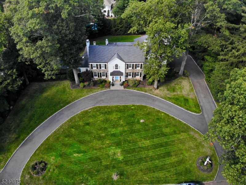 Magnificent center hall colonial perched on .9 acres of park-like property on a scenic, tree-lined street in one of Essex County's most desirable areas. With 6 bedrooms, 3 full bathrooms, 2 half bathrooms, a detached two-car garage, and a gorgeous patio and back yard swimming pool, this residence truly has it all! Everything has been renovated beginning 11 years ago to the present including a stunning new kitchen, modern luxury finishes, elegant custom trim work, crown molding, 2 primary bedroom suites, and so much more. A sweeping front lawn and semi-circular driveway bring you inside to a grand two-story foyer with an elegant, coffered ceiling and raised panel wainscoting. To your right is the gracious formal dining room with a fireplace and to your left is the large living room with another fireplace. An adjacent sitting room is perfect for entertaining with a beautiful built-in bar and views of the patio and grounds. Bring out your inner chef in the spacious gourmet kitchen equipped with a coffered ceiling, high-end appliances, extensive custom cabinetry, a huge center island, and a breakfast area. French doors open to the partially covered bluestone patio complete with a natural stone fireplace overlooking the private back yard and free-form pool - the perfect setting for cookouts and cocktail parties. This level continues with a family room,PR,W+D,mudroom. 2nd floor has 6 bedrooms 2 primary beds en suite,basement has rec room and fireplace.Top rated schools