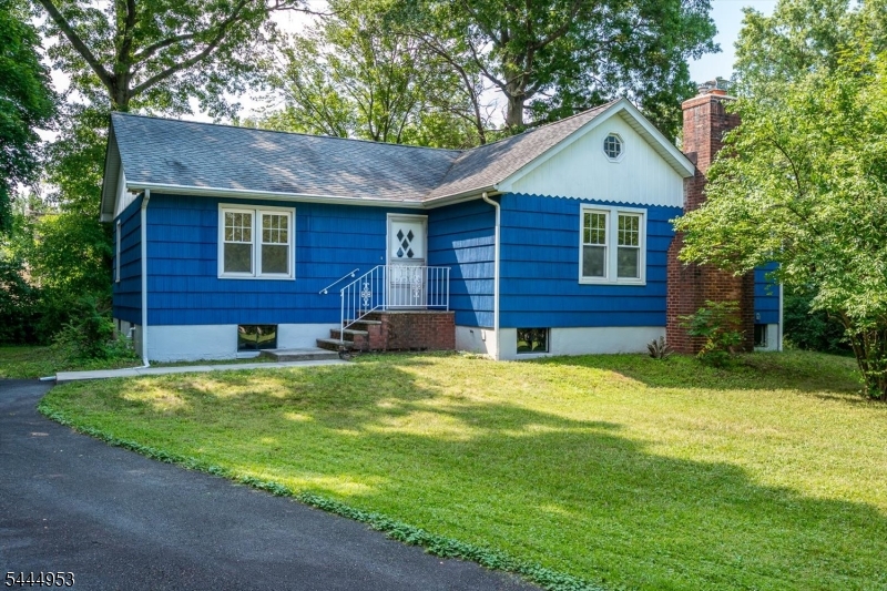 Nestled on a picturesque half-acre corner lot surrounded by mature trees, this charming 2-bedroom ranch offers privacy, character, and endless potential in a truly special setting. Inside, you'll find a surprisingly spacious floor plan featuring a sun-filled living room with a classic brick wood-burning fireplace, adjoining dining area, and beautifully refinished hardwood floors throughout much of the home. The eat-in kitchen has been refreshed with butcher block countertops, subway tile backsplash, luxury vinyl flooring, stainless steel refrigerator, and a new range, creating a clean, functional space with room for your own personal touches. Both bedrooms are generously sized with hardwood flooring, ample closet space, and abundant natural light. A full basement provides laundry, excellent storage, and endless possibilities for a workshop, home gym, or future finished living space. Outside, enjoy the detached one-car garage, long driveway offering ample off-street parking, expansive yard, and mature trees that create a peaceful, park-like setting. A walk-up attic offers additional storage. Whether you're buying your first home, downsizing to one-floor living, or looking for a property you can personalize over time, this home presents a wonderful opportunity in a desirable location with convenient access to shopping, dining, major highways, and commuter routes.