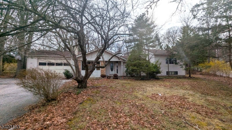 Located in the desirable Deer Trail Lake community, this light-filled 3-4 bedroom home offers flexible living space and year-round enjoyment. Two bedrooms are currently open to one another and could easily be converted to a legal 4th bedroom with the addition of a wall, closet, and door. The primary bedroom features its own private bath. A beautiful bay window and multiple skylights in the kitchen, bathroom, guest bedroom, and primary bath bring in abundant natural light throughout. Cozy up by the propane fireplace or unwind in the unique greenhouse-style spa room complete with jacuzzi and sauna. Additional highlights include a finished daylight walk-out basement, finished walk-up attic, sliders from the kitchen to the backyard, an oversized 2-car garage, and a shed with loft for extra storage. Optional lake membership offers swimming, fishing, and kayaking in a peaceful setting. Convenient to Route 23 and Route 94, approximately 10-15 minutes to Mountain Creek skiing and waterpark, 30 minutes to the Delaware Water Gap, and about 1 hour to NYC. Close to shopping, dining, golf, and year-round recreation. Property is being sold strictly as-is. Buyer responsible for any town/state certifications required to close.