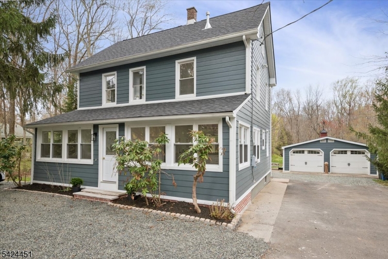 Set on a picturesque 2.32-acre property in the desirable Gillette section of Long Hill Township, this beautifully revived circa-1900 Colonial blends timeless charm with modern luxury. Thoughtfully reimagined, the home preserves its original character while incorporating today's most sought-after finishes. An inviting enclosed porch welcomes you into a warm interior where the original staircase serves as a striking focal point. The custom kitchen features high-end appliances, quartz countertops, gas cooking, and bespoke cabinetry, opening seamlessly to a spacious dining area ideal for everyday living. A comfortable living/family room, powder room, and a convenient laundry/mudroom with back access complete this floor. The 2nd level offers 3 well-appointed bedrooms, including a guest suite with ensuite, plus a full hall bath. The 3rd floor is dedicated to a private primary retreat with a luxurious five-piece ensuite, creating a true spa-like escape. The outdoor setting is equally impressive, backing a serene nature reserve with access to scenic hiking trails. A detached 2-car garage with workshop adds both charm and functionality. Additional highlights include: 2026 roof, manufactured wood flooring throughout, Hardie Board siding on house and garage, elegant crystal chandeliers. Awarded top-rated schools, Gillette train station, library, tennis courts, and baseball fields, this is a rare opportunity to enjoy privacy, space, and lifestyle in a prime Morris County location.
