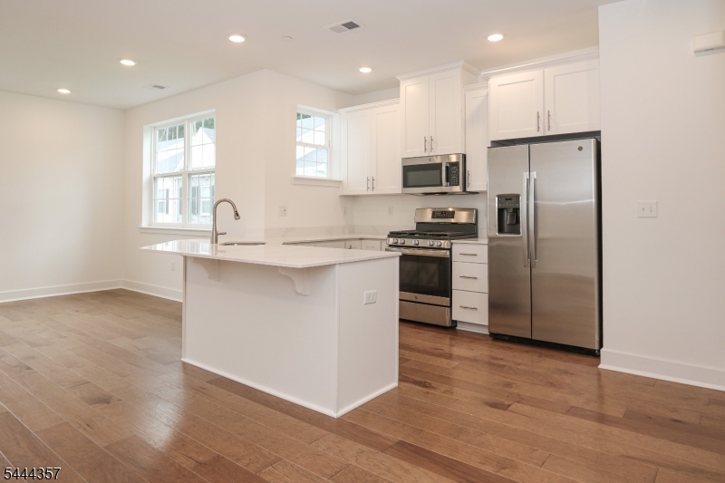 Welcome to Collections in Morris Plains, this commuter friendly community is located just minutes from the Morris Plains Train Station and provides easy access to several major highways. The bright and airy Hampton style end unit features an open concept main level with wide plank flooring throughout the living, dining, and kitchen areas. Quartz countertops, shaker style cabinets, stainless steel appliances, and kitchen island make for easy entertaining. Upstairs you'll find 3 generously sized bedrooms with walk-in closets, 2 full Bathrooms, Laundry area, and bonus Loft space. Other features include a primary bedroom with ensuite and California closet system, a built in garage, parking for 2 cars, and ample storage.  Shopping and dining options are plentiful in town as well as the surrounding areas including Morristown. Available immediately.