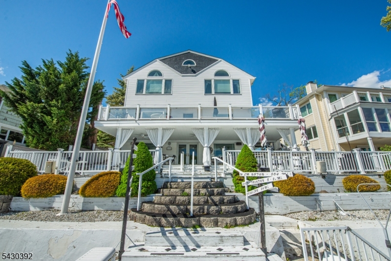 Experience lakefront living in this stunning single family home with panoramic views of the water.  The primary suite is a true sanctuary, water views, spacious bath complete with steam shower, jetted tub.  The second bedroom also features water views and a third bedroom for guest.  With 3 full baths and add'l half-bath this home combines luxury with functionally.  Wake up to water views, entertain on either of the 2 expansive decks w/outdoor kitchen, dock to hold 3 boats. Central Air, Whole House generator, parking for 12 cars.  Kitchen 2 ovens, microwave, built-in TV, 25 speaker in/outdoor surround system on both deck levels. No flood zone/No flood insurance required, new roof 2026, all utility  wiring underground, four lines for sewer (when or if sewer system replaces septic) integrated security & appliance control systems & 4 propane tanks (owned), Gas fireplace in living room, easy to clean tile flooring. Move in-ready, high-end lakefront home for everyone to enjoy all year round.  (SELLING AS-IS) Could possibly add on another living space. Driveway can be flattened need zoning permit.