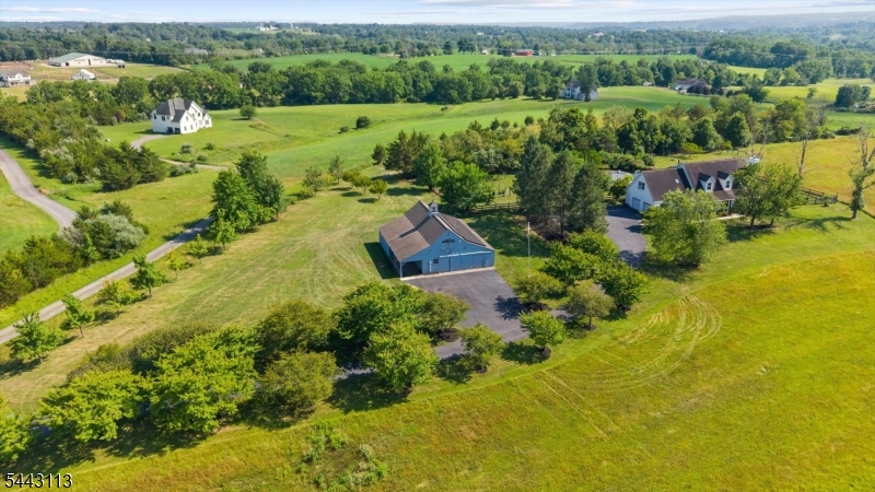 Spanning more than 10 scenic acres with horse potential, this farmhouse colonial strikes a rare balance of open living, privacy, and country charm. Soaring volume ceilings, hardwood floors, and sun-filled interiors set a warm, welcoming tone throughout. The open floor plan flows into a kitchen with a center island, maple cabinetry, and generous workspace, while a separate dining area and spacious fireplaced great room offer flexible space for everyday living and entertaining. A first floor den and full bath add versatility for guests or a home office. Upstairs, four generously sized bedrooms include a peaceful primary suite, complemented by two full baths. The fully finished basement adds room for recreation, fitness, or media enjoyment. The real showstopper is the land itself: fenced pastures, excellent riding and grazing potential, and a wonderful post-and-beam barn with a huge second floor suited to car collecting, farming, or its own retail storefront. Numerous additional outbuildings dot the property, including a smokehouse, offering endless options for hobbies, storage, or a working homestead. Landscaped grounds surround an inground pool with attached spa, in need of some TLC, but a fantastic bones and a rare amenity ready to be brought back to life. Whether you're envisioning horses, gardens, a car collection, or simply wide open countryside, this exceptional property delivers the space, setting, and lifestyle that make country living truly special. Farmland assessed.