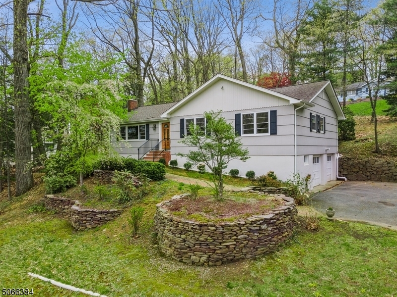 Beautiful Raised Ranch w/ 3 BRs, 2 BAs offers single floor living on an oversized lot w/ stunning views. Close to schools, restaurants, shops & NYC NJ Transit train. This sunny home is perfect for entertaining w/ a spacious LR that feats. a lrg picture window w/ lovely views & a cozy FP & opens to a DR w/ another big window feats. back yard views & a 3 season rm that  inc. a separate ent. EIK incs granite ctrs, ample cabinets, ss apps & opens to a lrg patio & private back yard - a great space for hosting or relaxing as you listen to birds singing. Down the hall are 3 lrg BRs, inc a MBR w/ a WIC & en suite BA & a full hallway BA. A finished basement offers a spacious fam rm ideal for movie night & also has an office/game room area, laundry rm, lots of storage space & access to the attached two-car garage.