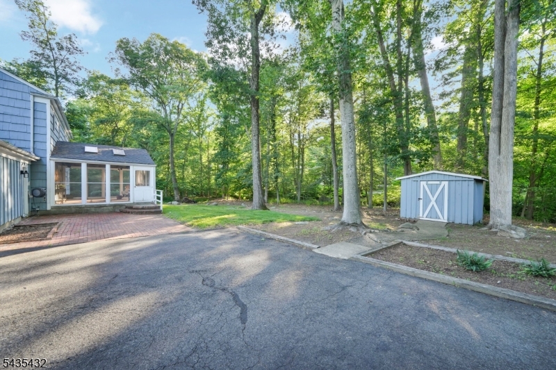 Nestled in one of Lake Valhalla's most sought after neighborhoods, this charming 4 bedroom, 2.5 Colonial offers the perfect blend of comfort, community, and location.  Just steps from the amenities and activities of Lake Valhalla Club, this home places you in the heart of a vibrant neighborhood known for its annual block parties, and strong sense of community. The first floor features a spacious country kitchen, formal dining room, inviting living room, and a cozy family room, providing plenty of space for both every day living and entertaining.  A convenient laundry room and powder room add functionality, while the stunning three season porch serves as the true highlight of the home.  Showcasing vaulted ceilings with Craftsman-style beams, this light filled retreat is the perfect place to relax and enjoy the peaceful surroundings. Upstairs, you will find four generously sized bedrooms and two full bathrooms.  The recently renovated hall bath offers gorgeous modern features and thoughtful updates that today's buyers will appreciate.  Create your own vision with a blank canvas full unfinished basement or utilize the storage and workshop already there waiting for you! Step outside to a beautifully landscaped open back yard that backs up to a babbling brook, creating a serene natural setting and wonderful space for your outdoor enjoyment.  With its desirable floorplan, amazing setting, and unbeatable location, don't miss the rare opportunity to make this house your home.