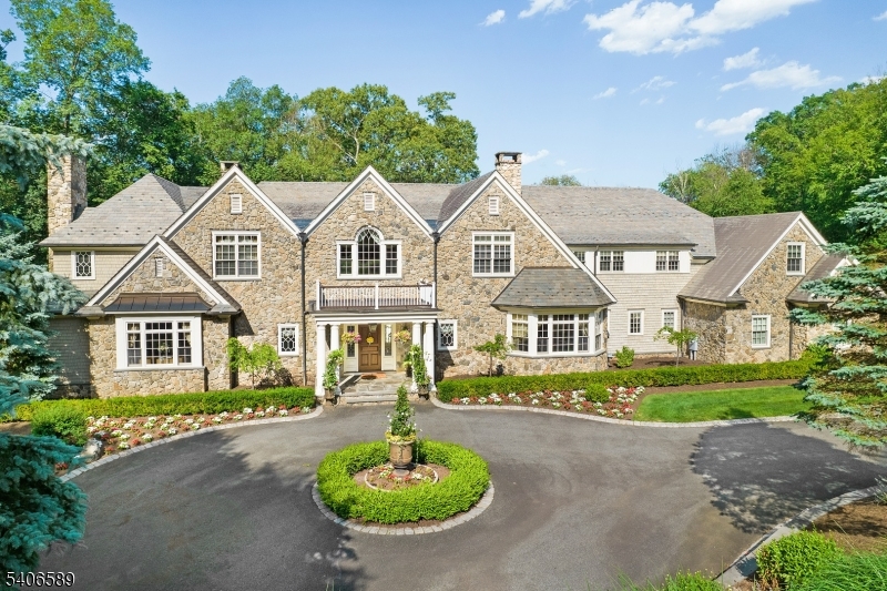 Absolutely stunning stone front Manor House perfectly embodies the joy of graceful living with 9,125 sq. ft. of commodious living space on the two upper floors, plus the added luxury of a sprawling, magnificently finished 2,800 sq. ft. lower level with walkout, & 23.7 private woodland acres with FORESTRY TAX SAVINGS STARTING JAN 2027.  Sited at the very end of a quiet cul-de-sac in a coveted Roxiticus Valley neighborhood, with the added pedigree of a Far Hills mailing address.  21 rooms including 7 airy bedrooms with superb primary bedroom suite, 7 full baths, 3 powder rooms, 6 fireplaces, formal living room has radiant picture window with transoms, soaring great room with exposed beams, stacked windows, & wet bar, gorgeous gourmet designer kitchen replete with large center island with prep sink, premium appliances, & adjoining breakfast room ,well-appointed butler's pantry, tasteful dining room boasts stylish center chandelier & resplendent wall of windows, handsome library with built-ins & convenient access to the 3-season porch, first-floor guest bedroom, outstanding mudroom area with built-ins.  Volume coffered & tray ceilings, custom millworker & lighting, radiant heat, & lustrous hardwood flooring throughout- this outstanding home has a heated 4-car attached garage with  EV charging station. Private showcase property with sprinkler system, night accent lighting, & back-up generator. Freshly painted exterior.Top-rated Mendham Twp schools & commuter-friendly location.