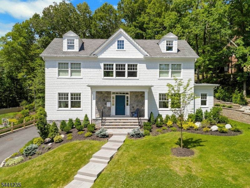 Welcome to this exceptional open-concept home located in the Hartshorn section featuring 6 bedrooms, 5.5 baths, and refined craftsmanship throughout. A dramatic 20+ foot entry ceiling, custom steel staircase, 10-foot ceilings, oversized windows, and 6-inch white oak floors create a bright, sophisticated interior. The elegant dining room showcases oversized wainscoting and abundant natural light.  The gourmet kitchen features quartz countertops, soft-close cabinetry, oversized Sub-Zero refrigerator/freezer, Wolf range, espresso bar, and full-height pantry. The kitchen flows into a spacious family room with coffered ceiling and gas fireplace, complimented by a versatile office/playroom.  The second floor offers four bedrooms, including a luxurious primary suite with vaulted ceiling, oversized walk-in closet with island, balcony, and spa-like bath. The third floor provides flexible living space with an additional bedroom, flex space and a full bath. The finished lower level includes a bedroom suite, full bath, mudroom, recreation space, and gym area. Set on approximately half an acre with wooded, sunset views, this home features a custom outdoor grilling area, a full house generator, multi-zone HVAC, and a 3-car garage.