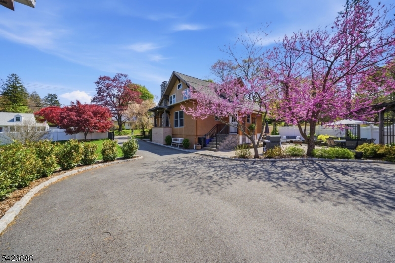 An exceptional custom home set on over a .25ac of private, beautifully landscaped property. This rare offering combines timeless architectural charm with modern updates, all supported by Randolph's rare & highly sought after public utilities, including water, sewer & natural gas. The fully fenced yard features a large gated driveway entrance, expansive lawn space & a stunning paver patio surrounded by gorgeous landscaping, creating a serene outdoor setting. A detached 3 car garage offers incredible versatility, plus full basement for addtl storage or workspace. The home showcases classic Craftsman details at every turn, including exposed woodwork, coffered ceilings, rich moldings, stone accents, built ins, solid wood doors & HW floors. A striking stone faced fireplace anchors the living space, adding warmth & character. The home has been thoughtfully updated to preserve its historic charm while incorporating modern conveniences. The layout provides flexibility for a variety of living needs. The updated eat in kitchen features radiant heated floors, blending comfort & functionality. The primary suite includes a sitting area & access to a private deck. Addtl highlights include a newer CA system (just 2 yrs old) & an overall level of craftsmanship rarely found today. A truly special home that offers character, space, & privacy while still being conveniently located near schools, shopping, dining, & major commuting routes. Lot next door is NOT included in this sale.