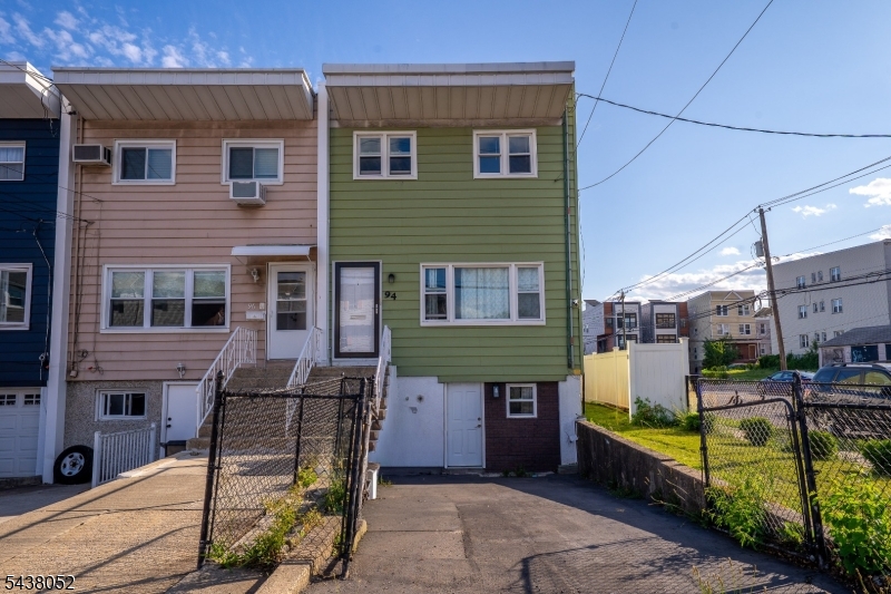 Welcome to this beautifully updated duplex-style end-unit in the heart of Bayonne! This 3-bedroom, 2.5-bath home offers the space and flexibility buyers are looking for ? all just minutes from NYC. Step inside to a spacious open-concept living area with gleaming hardwood floors, a ceiling fan, and natural light throughout. The layout flows seamlessly into the kitchen, making it ideal for entertaining. Upstairs you'll find three generous bedrooms with hardwood floors and ample closet space, plus a fully renovated full bathroom featuring modern tile work, an updated vanity, and contemporary fixtures. A convenient half bath on the main level rounds out the upper floors. The finished basement adds valuable living space ? perfect as a guest suite, home office, or media room ? complete with recessed lighting and its own separate entrance. Outside, enjoy your private fenced backyard with a brick paver patio, a wooden deck perfect for grilling and relaxing, plus a grassy yard ? a rare find in Bayonne. Solar panels are already installed, helping to reduce energy costs. Off-street driveway parking adds everyday convenience. With easy access to the Hudson-Bergen Light Rail, NJ Transit buses, and major highways ? your commute to Manhattan is under an hour. Don't miss this one.